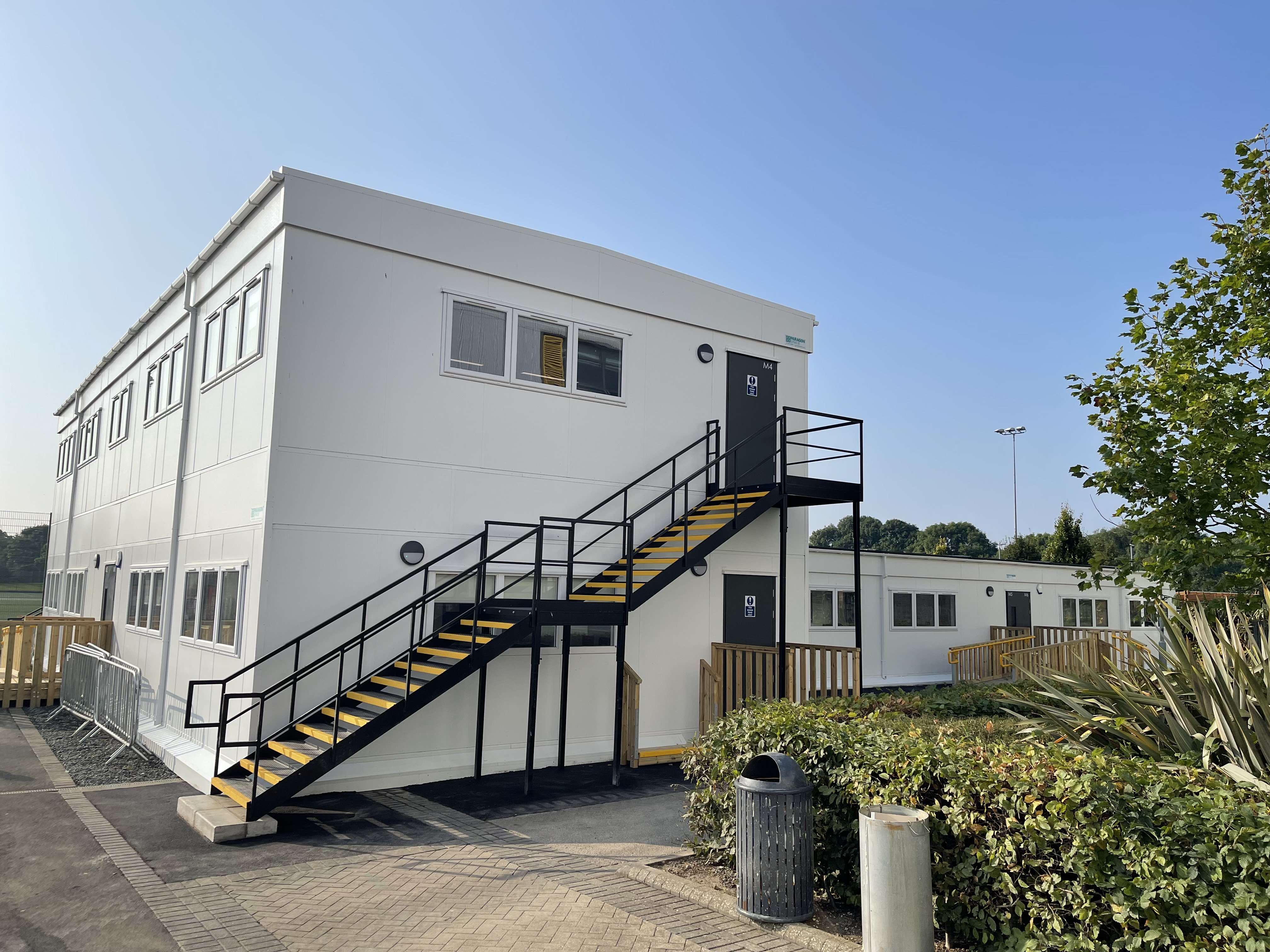 Side view of two storey modular building with staircase.